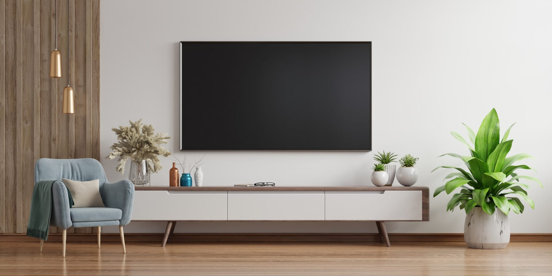 Smart TV on the white wall in living room with armchair,minimal design. Smart TV on the white wall in living room with armchair,minimal design.