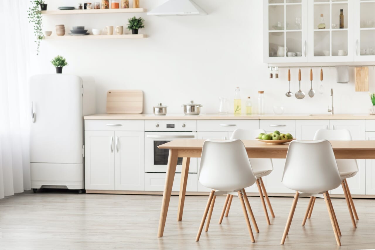 Minimalist design of kitchen. Dining table with white chairs and furniture with utensils, small Minimalist design of kitchen. Dining table with white chairs and furniture with utensils, small